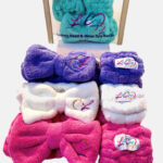 Colorful, fluffy headbands with embroidered logos, arranged neatly.