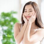 Woman enjoying a refreshing facial moment with eyes closed.