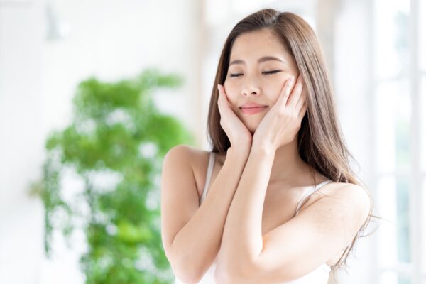 Woman enjoying a refreshing facial moment with eyes closed.