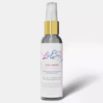 Elegant spray bottle with a gold cap and pastel label design.