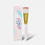 A makeup brush with white and pink bristles and a decorative box.