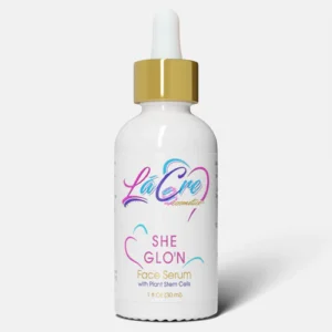 A white dropper bottle labeled 'She Glows' with colorful text and a gold cap.