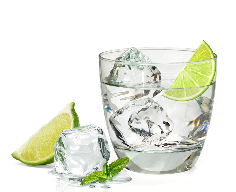 Glass of ice water with lime and mint leaves.